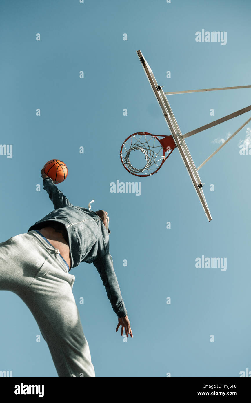 Bajo el ángulo de un jugador de baloncesto saltando Foto de stock