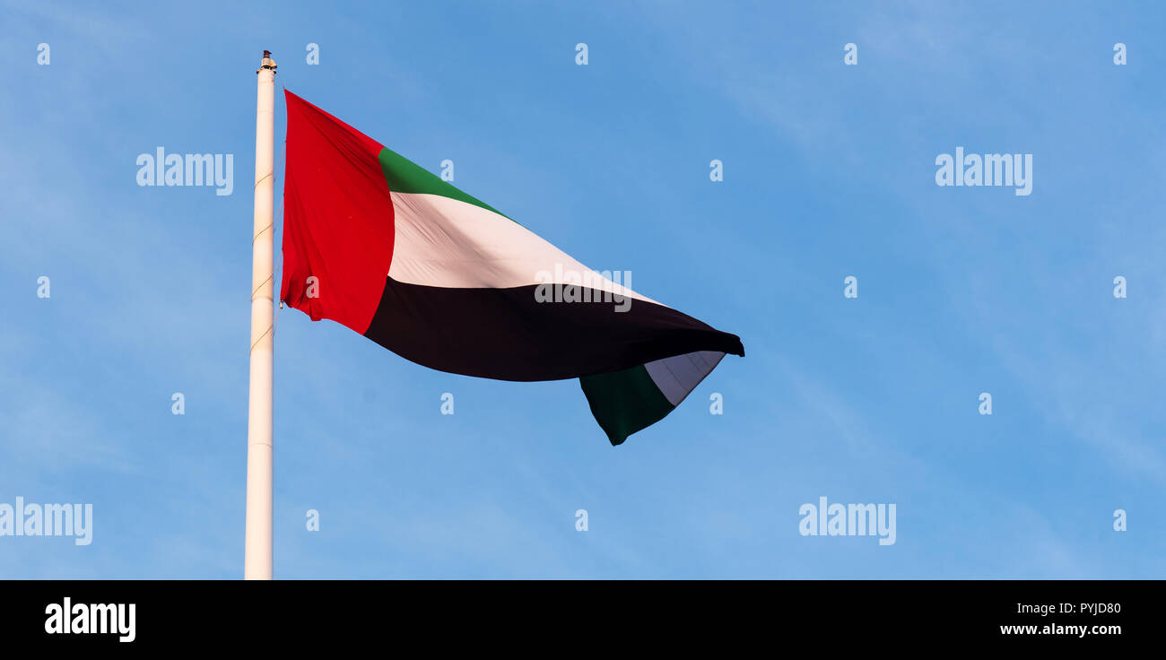 Bobinado de bandera de los Emiratos Árabes Unidos en el viento contra el cielo azul Foto de stock