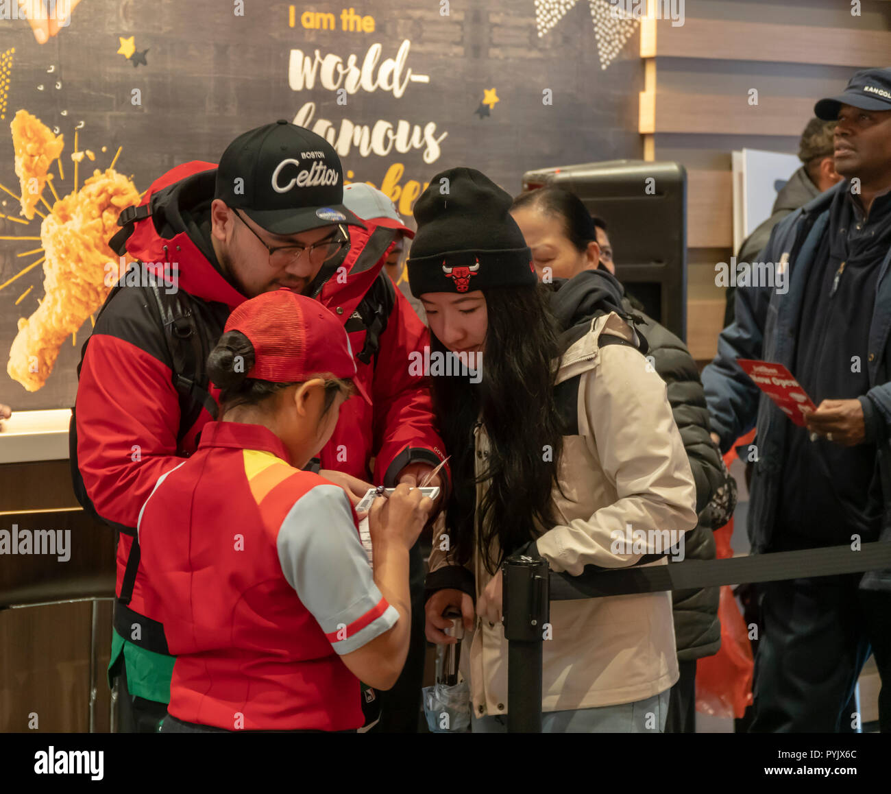 Nueva York, Estados Unidos. 28 Oct, 2018. Los trabajadores tomar pedidos en la cola en el restaurante de comida rápida Jollibee en Midtown Manhattan en Nueva York en el día de la apertura, el sábado, 27 de octubre de 2018 . La cadena de restaurantes, que ha sido bautizada como el McDonald's de filipinas debido a su ubicuidad y popularidad en el país, abrió su primera ubicación en Manhattan, en la zona de Times Square. Alimentos Jollibee Corp., que tiene planes de abrir cientos de tiendas en los EE.UU. y Canadá también posee una participación en la cadena Smashburger. (Â© Richard B. Levine) Credit: Richard Levine/Alamy Live News Foto de stock
