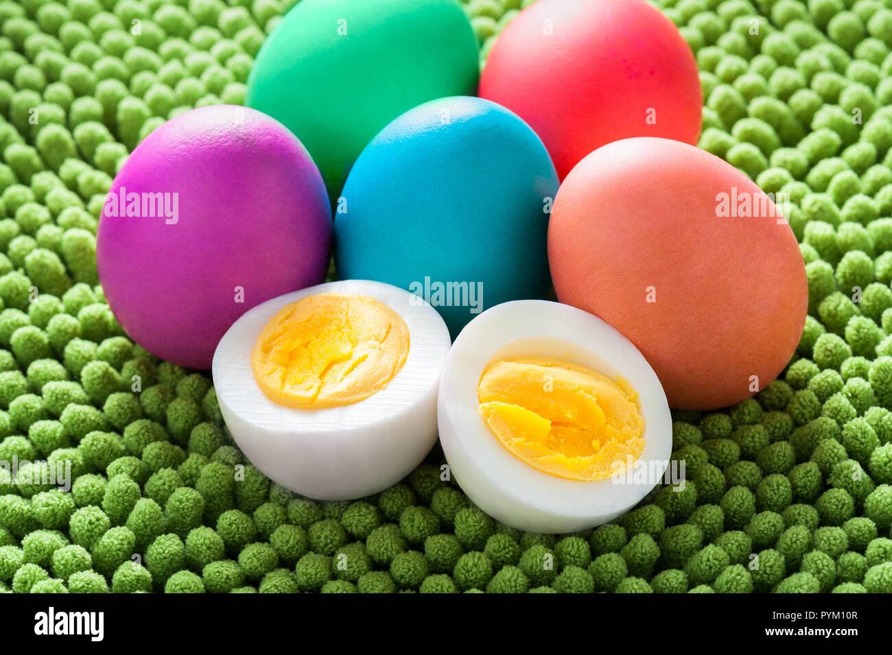 Huevo de Pascua de colores neón bodegón con corte y huevo duro. Foto de stock