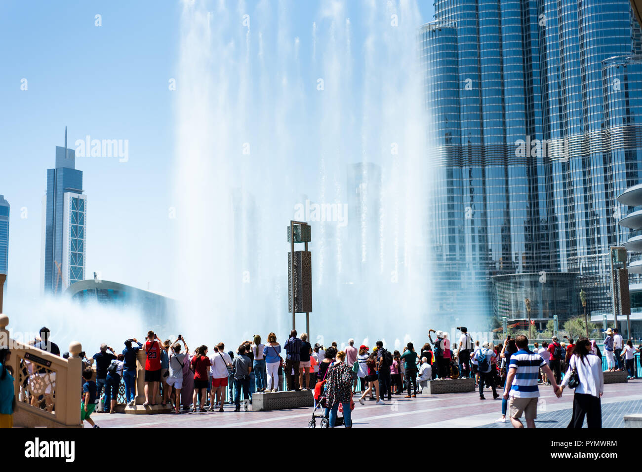 Dubai, Emiratos Árabes Unidos - Marzo 26, 2018: la gente se reúne alrededor de la fuente de Dubai Mall para ver el espectáculo de agua que atrae a muchos turistas cada día Foto de stock