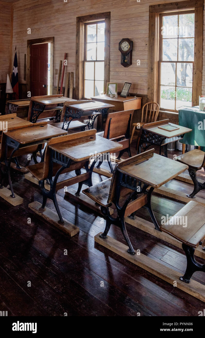 Vintage aula en una habitación vieja escuela con escritorios y sillas de madera de estilo rústico. Wilmeth Schoolhouse, plaza de castaños, McKinney Texas retrato. Foto de stock