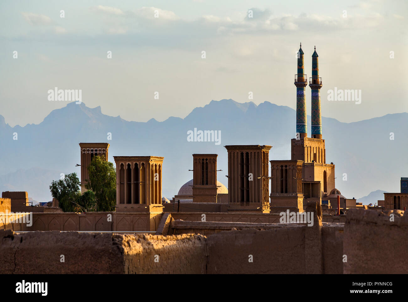 Vistas de los tejados del casco antiguo de la ciudad de Yazd, en Irán con mezquitas y atrapadores de viento (wind tower) en la distancia. Foto de stock