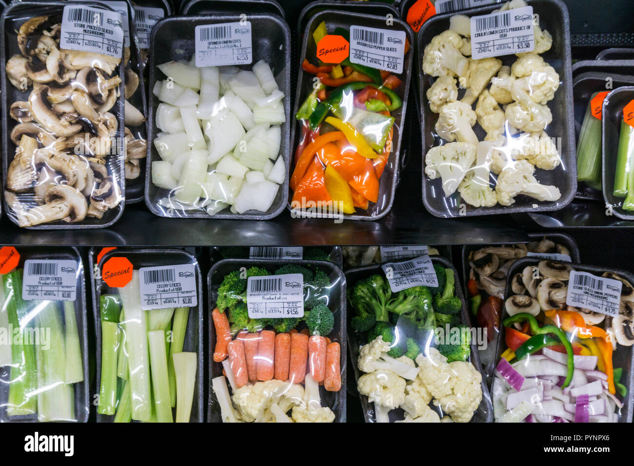 Preparados vegetales en envoltura retráctil de plástico en los estantes de un supermercado de Canadá. Foto de stock