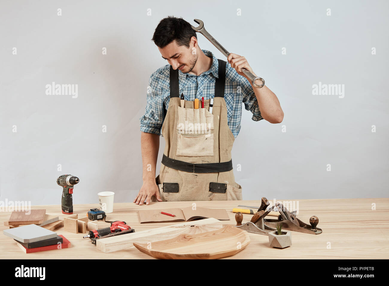 Macho emocional carpintero en ropa de trabajo y delantal habiendo  confundido perplejo mira Fotografía de stock - Alamy