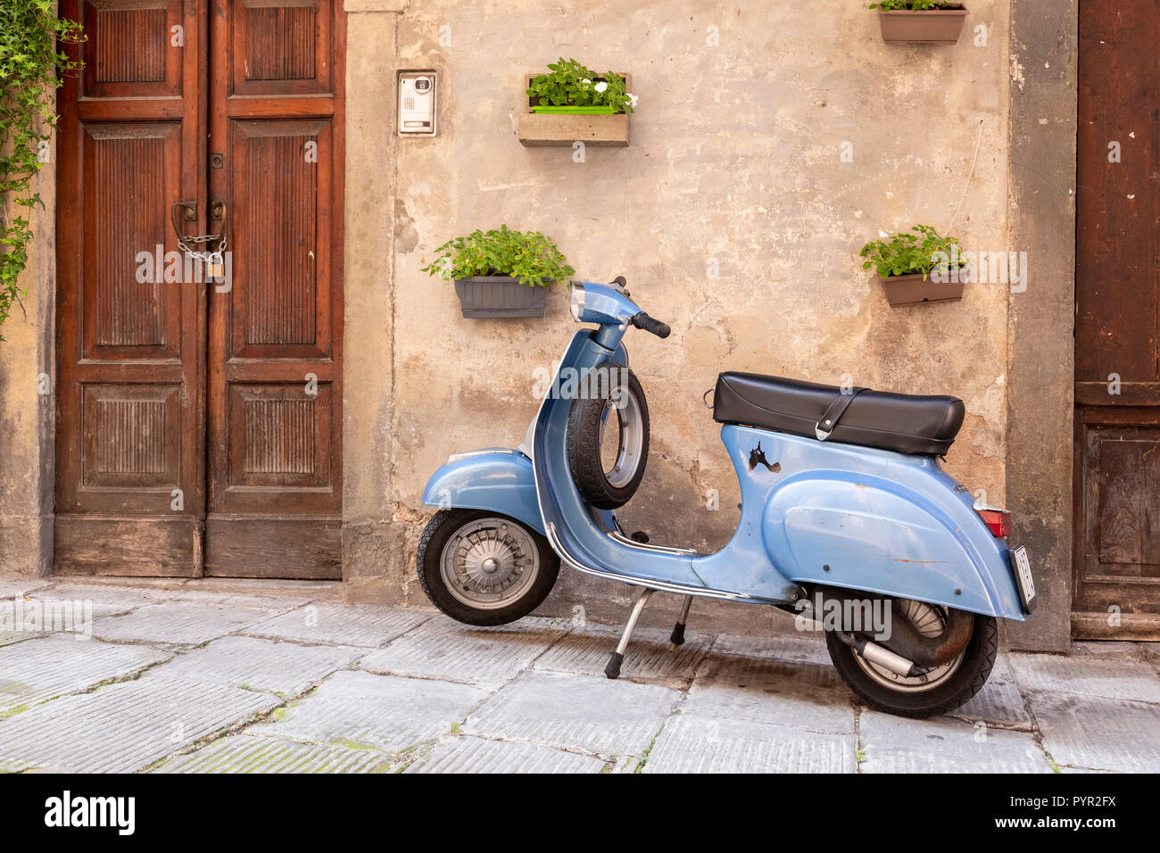 Scooter aparcado por una puerta de madera en Lovere en lago de Iseo, Italia Foto de stock
