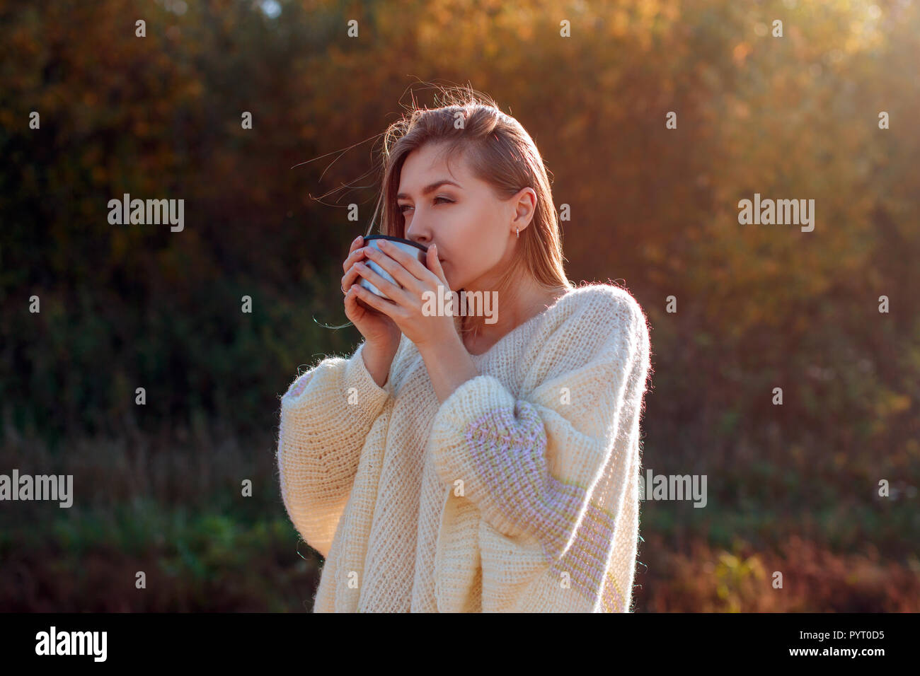 Hermoso admirando la mujer beber té caliente de taza termo Foto de stock