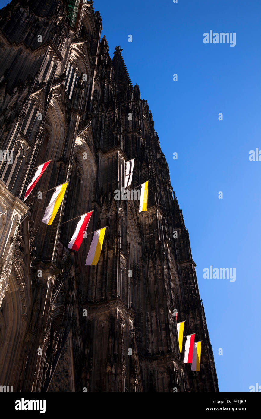 Banderas en la fachada occidental de la catedral de Colonia, Alemania. An der Westfassade Falggen des Doms, Koeln, Deutschland. Foto de stock