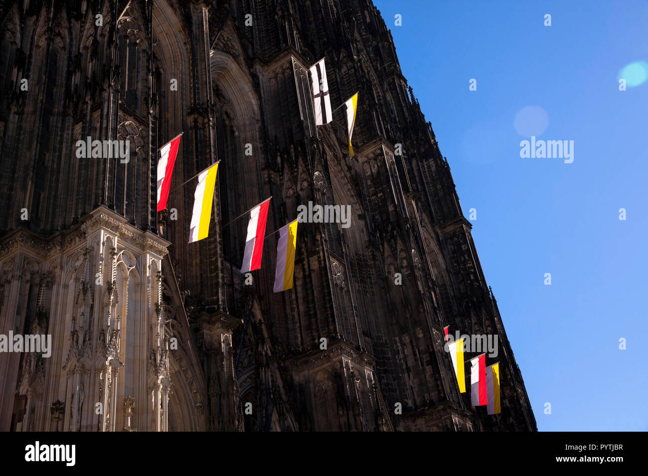 Banderas en la fachada occidental de la catedral de Colonia, Alemania. An der Westfassade Falggen des Doms, Koeln, Deutschland. Foto de stock