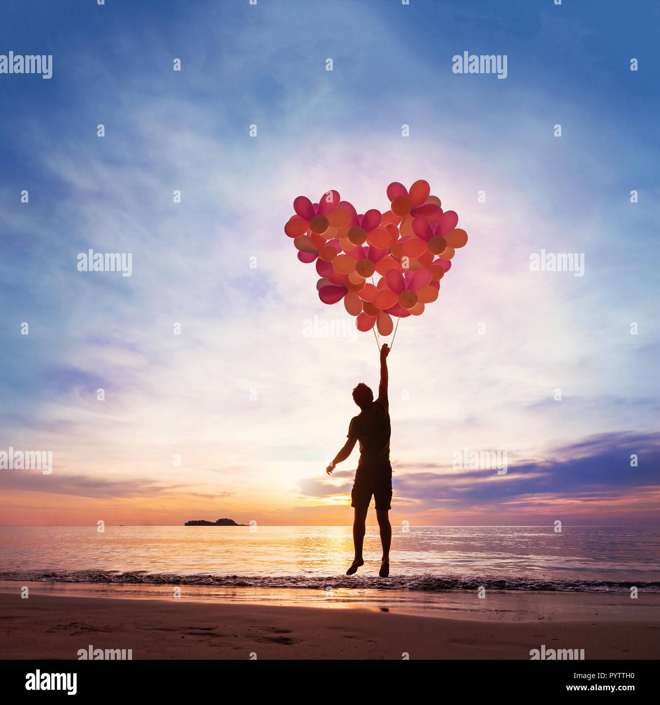 Concepto de bondad y amor, niño volando con corazón desde globos. Foto de stock