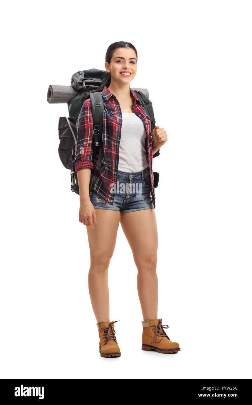 Excursionista hembra con mochila de pie y mirando a la cámara aislada sobre fondo blanco. Foto de stock