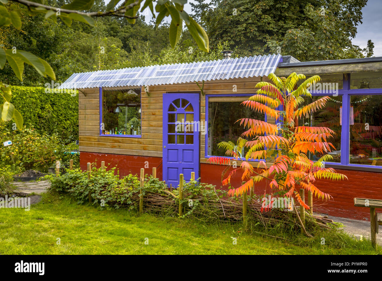 Poco garden guest house cottage con plantas y árboles de colores otoñales Foto de stock