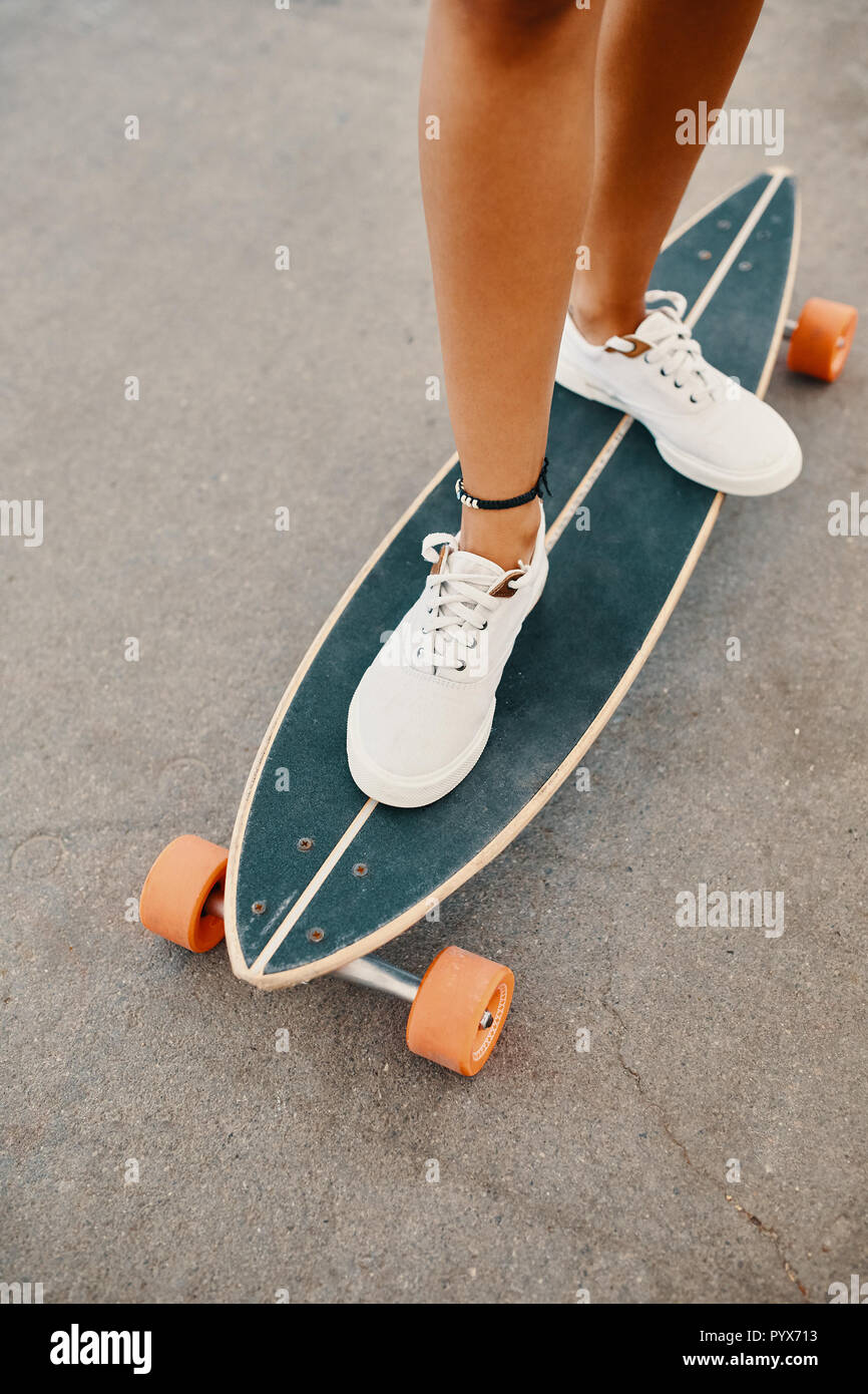 Cerca de la de piernas en blanco zapatillas sobre longboard Fotografía de stock - Alamy