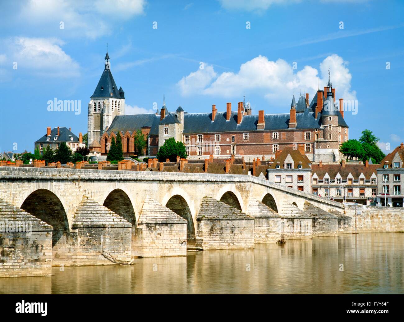 Sobre el río Loire a los 16 C. puente de piedra, el castillo real y la ciudad de Gien en Loiret departement, Francia Foto de stock