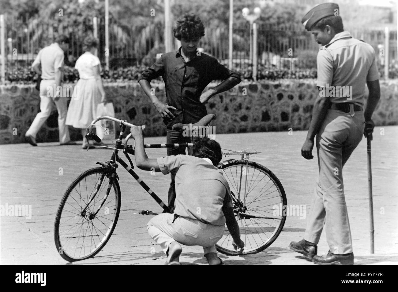 La policía hombre quitar el aire desde la bicicleta, Bombay, Maharashtra, India, Asia, 1900 Foto de stock
