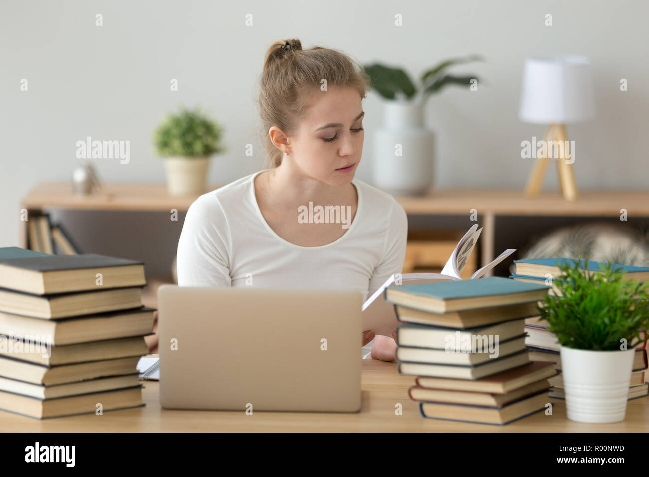 Joven Mujer concentrada estudiando sentado al escritorio Foto de stock