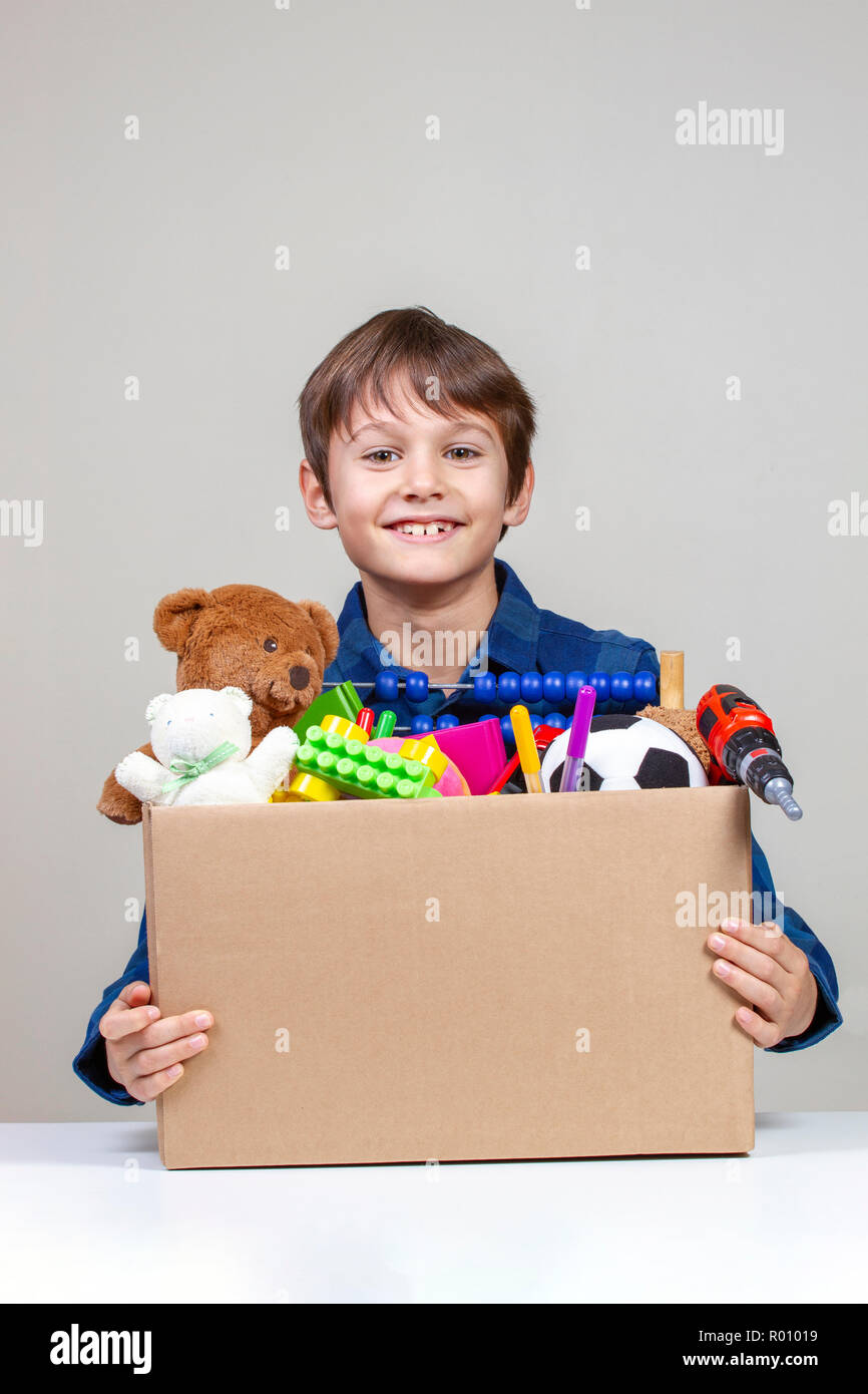 Concepto de donación. Kid celebración donar caja con ropa, libros y juguetes  Fotografía de stock - Alamy