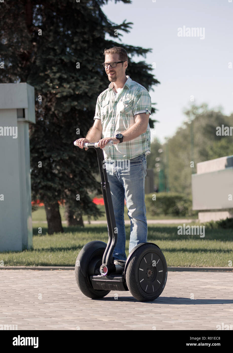 Feliz el hombre moderno montando un mini hoverboard en el parque Fotografía  de stock - Alamy