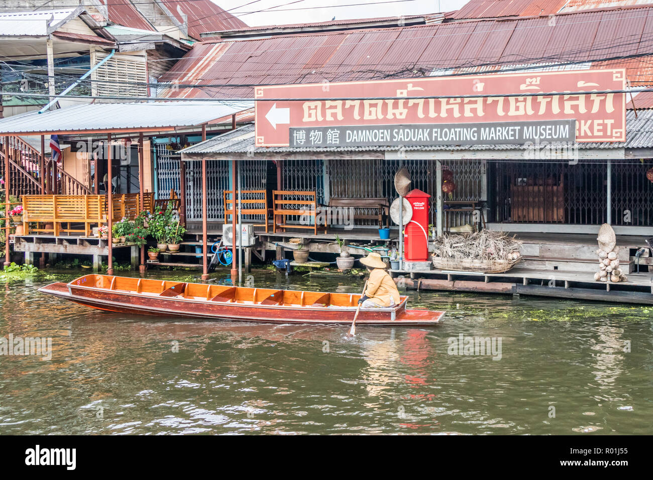 Damnoen Saduak, Tailandia - 8 de octubre de 2018: un barco pasa por el mercado flotante en museo. El mercado es un destino turístico muy poular. Foto de stock