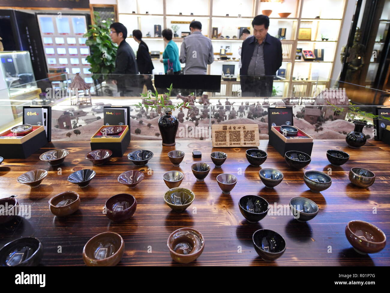 (181031) -- JIANYANG, Octubre 31, 2018 (Xinhua) -- Los turistas ver 'Jian Zhan', una especie de barniz negro bowl, en una sala de exposiciones en Jianyang, sudeste de China Provincia Fujiang, el 29 de octubre, 2018. "Jian Zhan', una especie de Esmalte vidriado negro temmoku o porcelana, luego fue utilizado sólo por los emperadores de la antigua China La dinastía Song (960-1279). Famoso por su nobleza y gorgeousness, 'Jian Zhan' era numeroso exportada al exterior a través de la ruta de la Seda en el mar. Sin embargo, después de la dinastía Song, las tradicionales técnicas de cocción para hacer 'Jian Zhan" no pudo ser transferido a las futuras generaciones. En los últimos años, th Foto de stock