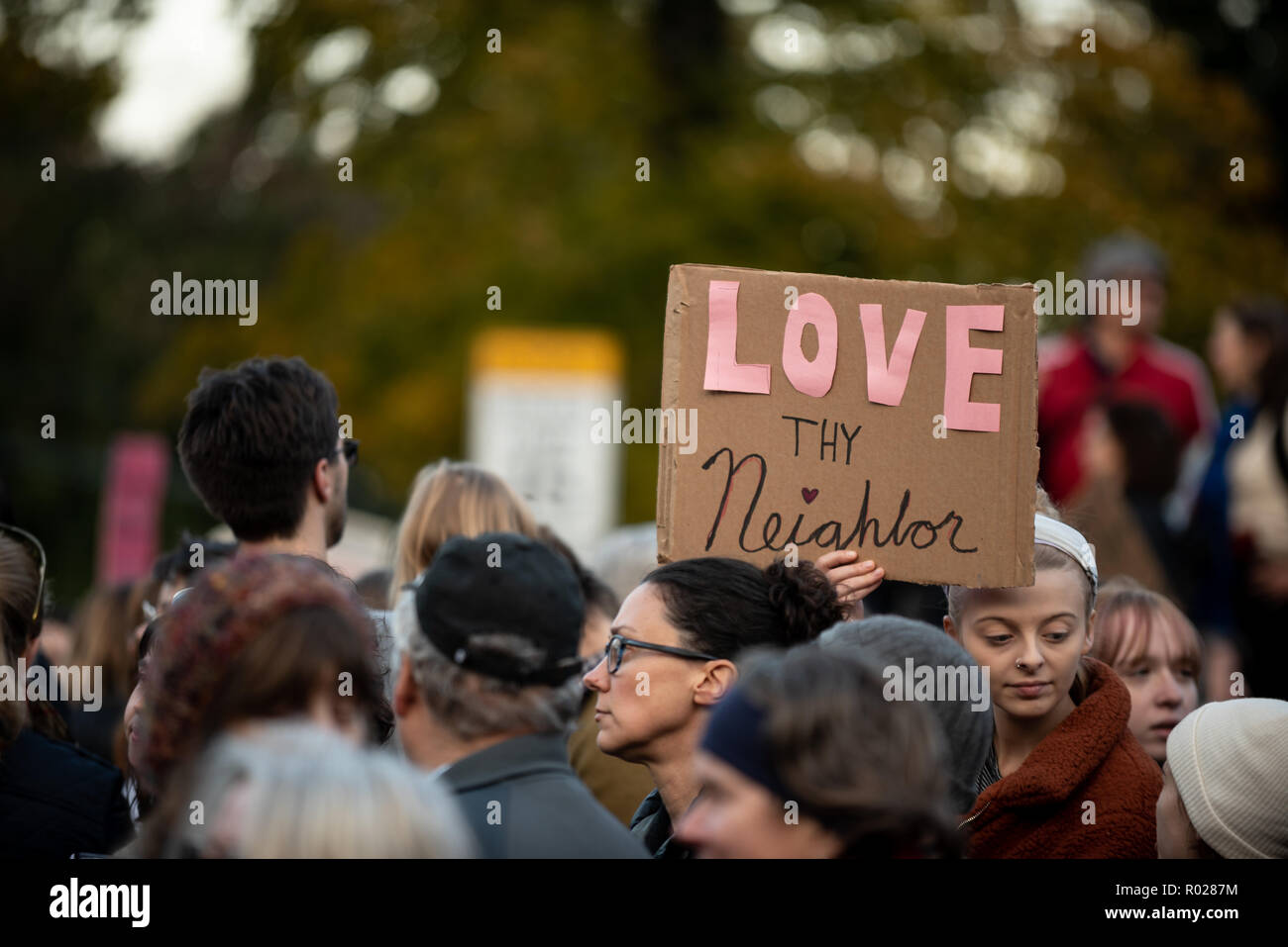 Un cartel visto durante la marcha se lee "amor al prójimo", refiriéndose al Sr. Rogers. Miles de personas participaron en una marcha en Pittsburgh para rendir homenaje a las víctimas que perdieron sus vidas en los árboles de la vida disparando. Foto de stock