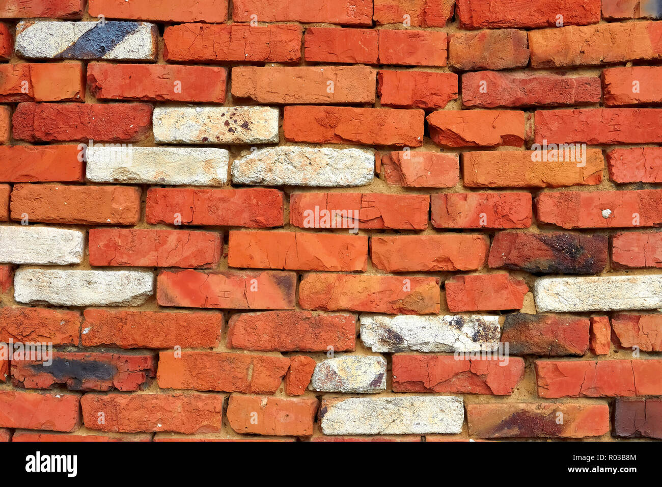 Fragmento de una pared de ladrillo rojo con unos ladrillos refractarios ladrillo de sílice blanca Foto de stock
