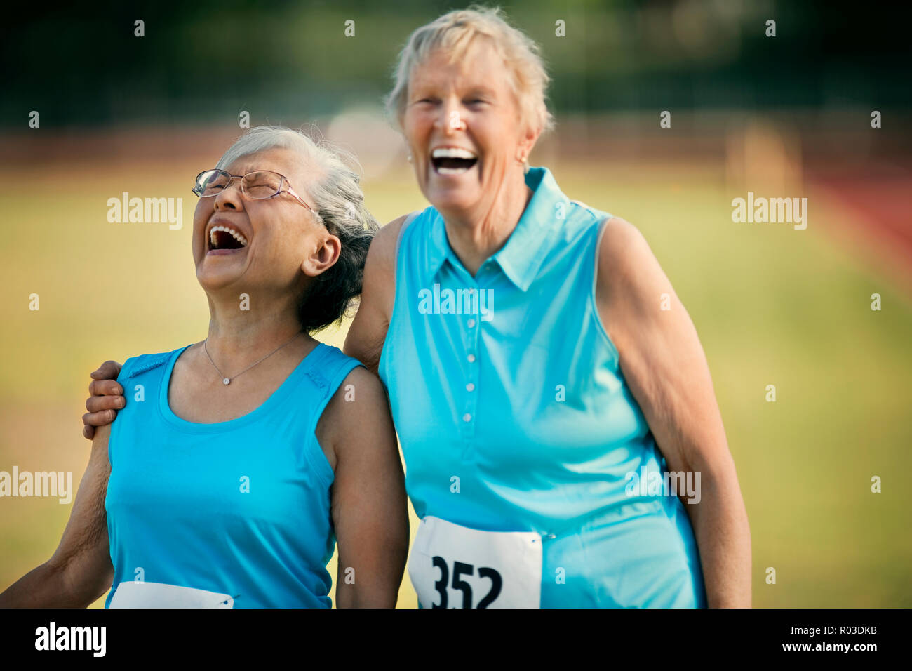 Dos mujeres de edad feliz riendo después de competir en un evento atlético. Foto de stock