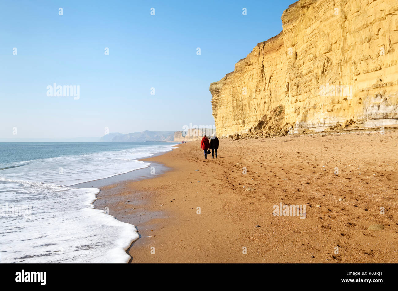 Las parejas ancianas caminando a lo largo de la parte occidental de Cesil Beach en Burton acantilado en la Costa Jurásica, cerca de Bridport, Dorset, Inglaterra, Reino Unido. Foto de stock