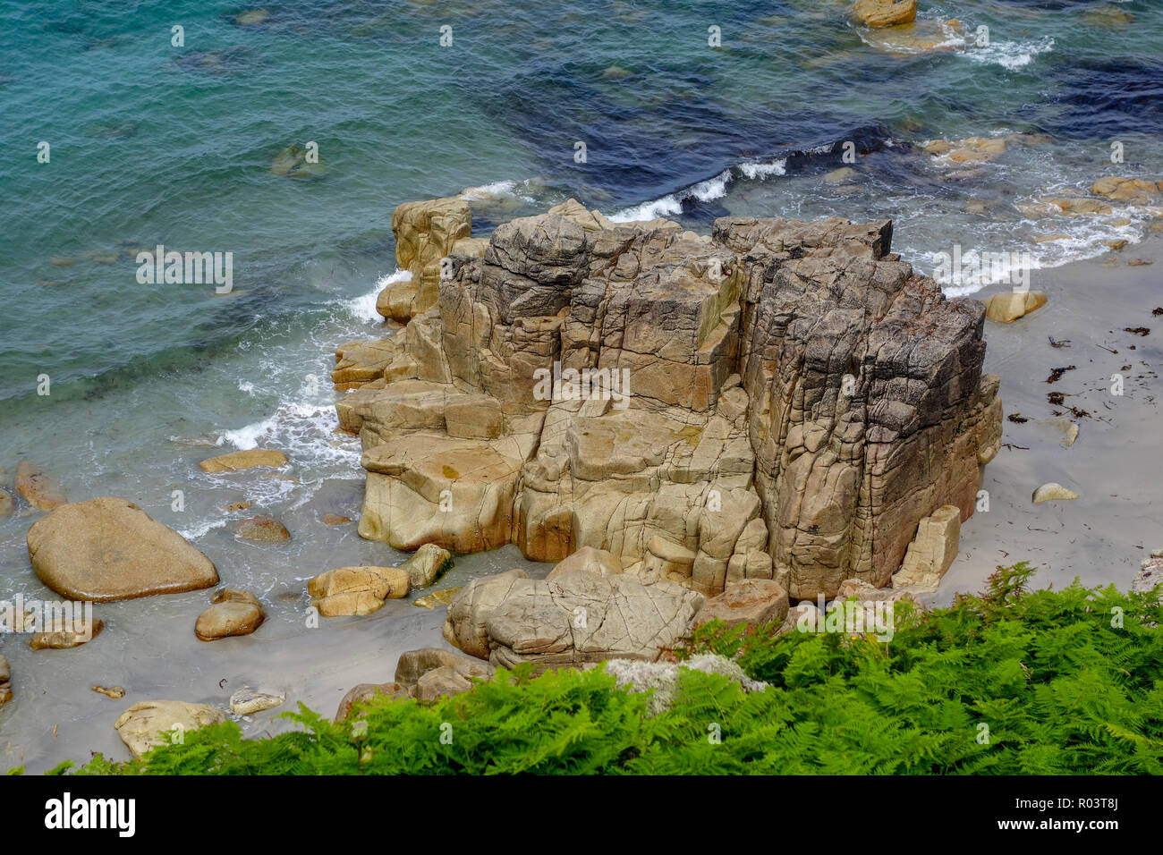 Tiempo gastado una roca en el mar cerca de la cuna Valley, San Justo, Cornwall, Inglaterra, Reino Unido. Foto de stock