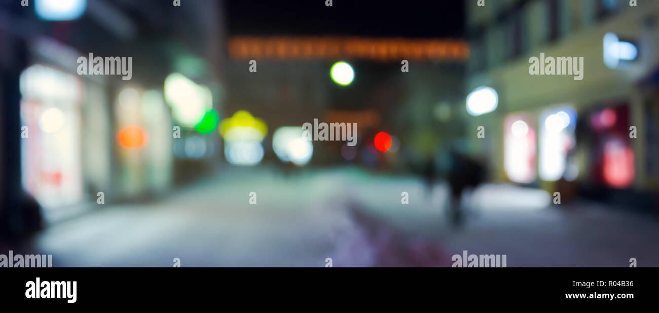 Panorama de la calle de noche en invierno. ciudad luz y brillantes escaparates. Las ventas navideñas concepto fondo borroso. Foto de stock