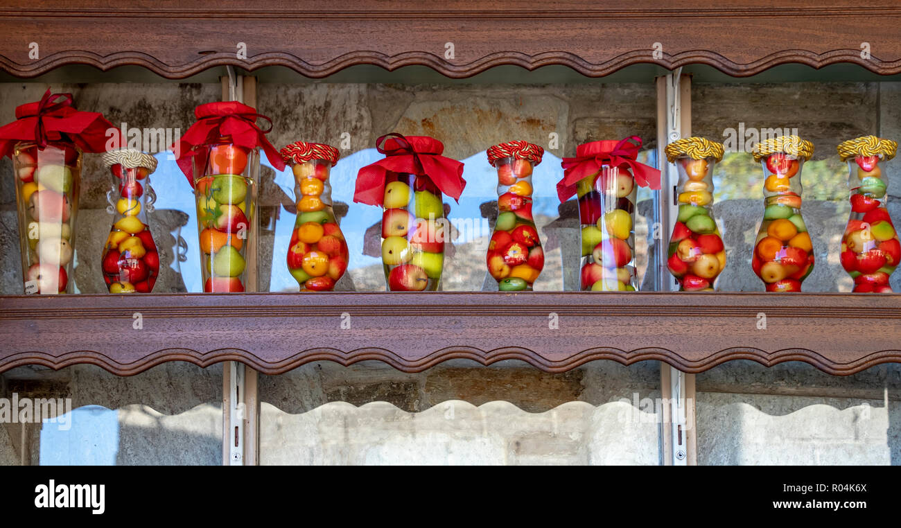 Frascos decorativos de vidrio con tapas de colores llenos de diversas frutas Foto de stock