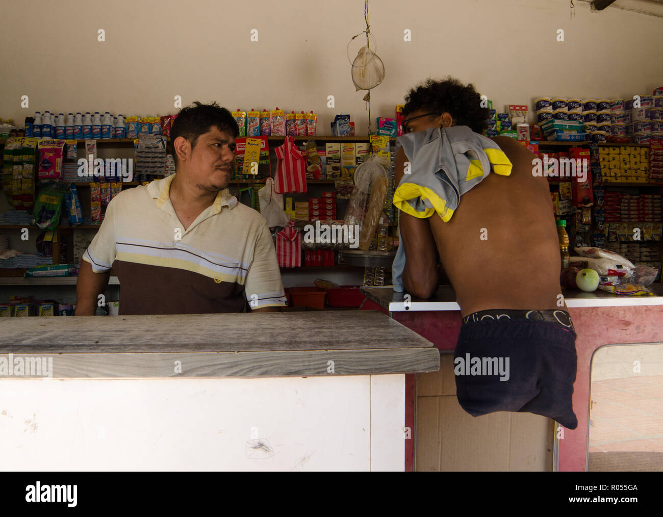 Barranquilla, Colombia. 21 Oct, 2018. Alfonso Mendoza (r) de Venezuela, habla con el dueño de una pequeña tienda en la ciudad colombiana de Barranquilla. Mendoza nació sin piernas, pero él nunca dejaba de estar parado. A los 25 años es un skater, surfer y rapero y recientemente se ha convertido en un padre. Al igual que cientos de miles de sus compatriotas, el venezolano huían del hambre, la miseria y la opresión en su natal Venezuela. (Dpa "contra todas las fronteras: los venezolanos sin piernas lucha por la normalidad" de 02.11.2018) Credit: Natalia Ortiz Mantilla/dpa/Alamy Live News Foto de stock