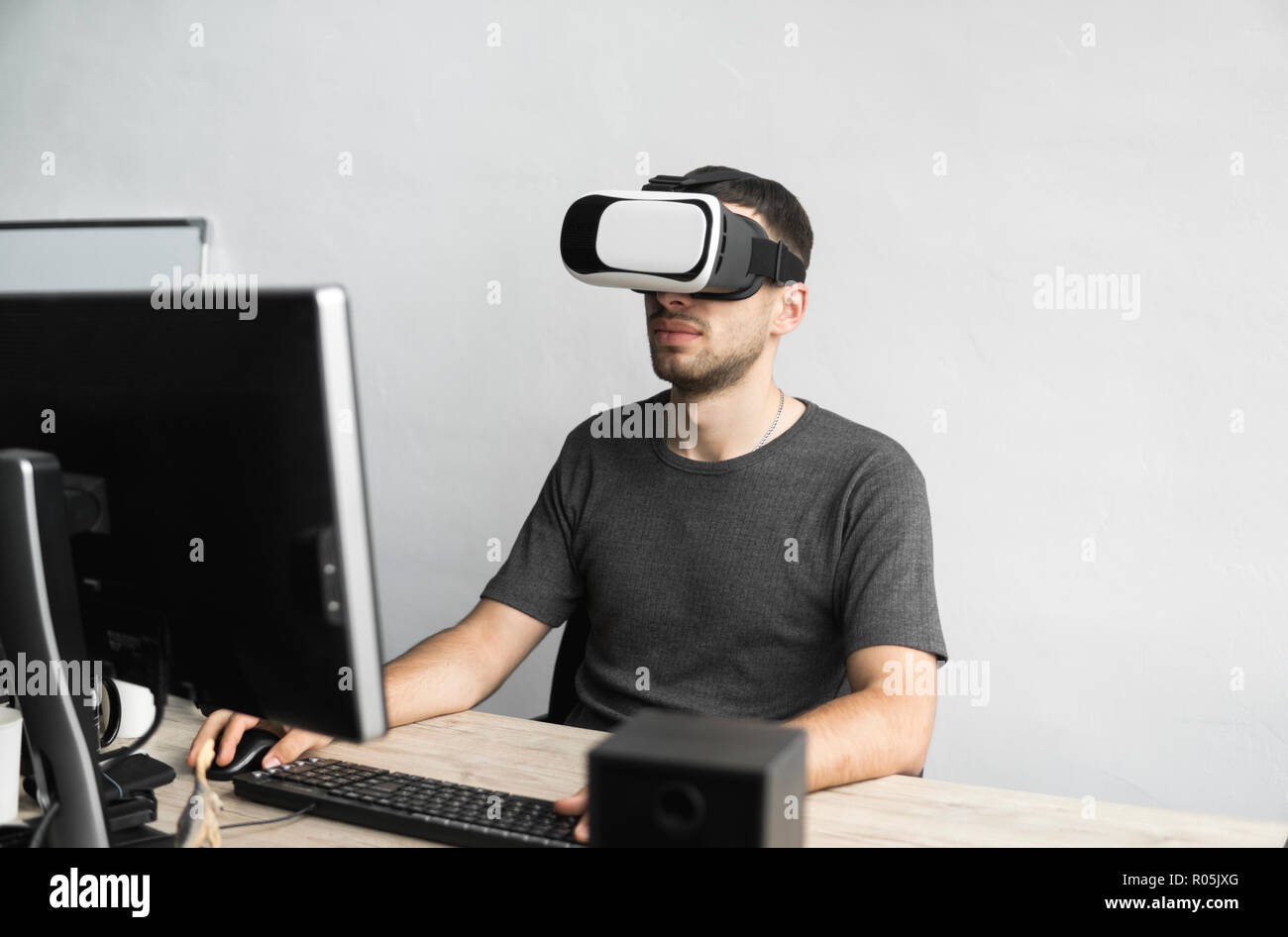 Joven llevaba gafas de realidad virtual headset, vr box y sentado en la  oficina contra el monitor del equipo. La conexión, la tecnología, la nueva  generación, el concepto de progreso Fotografía de