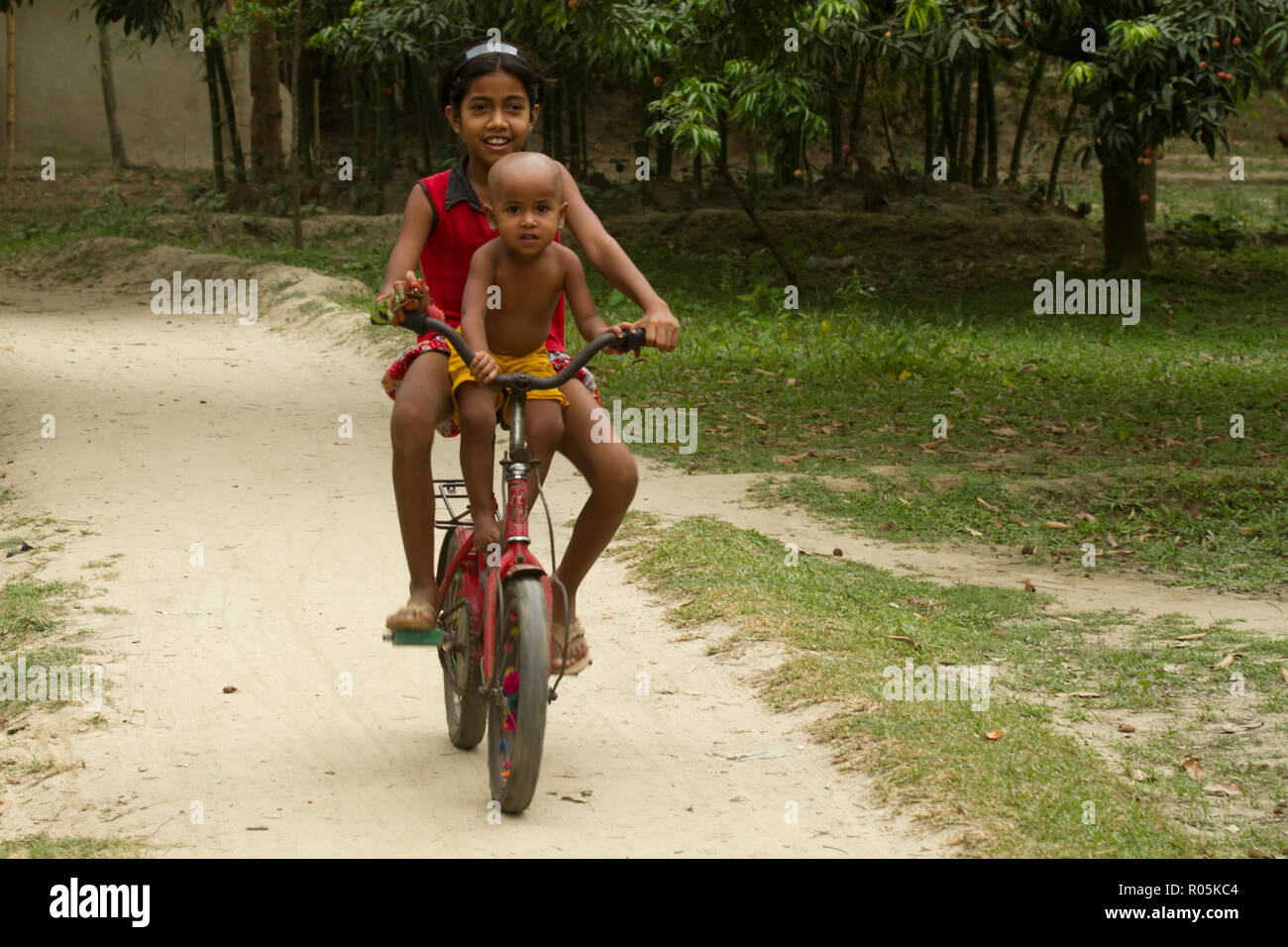 Niña paseos en bicicleta. Dinajpur (Bangladesh). Foto de stock