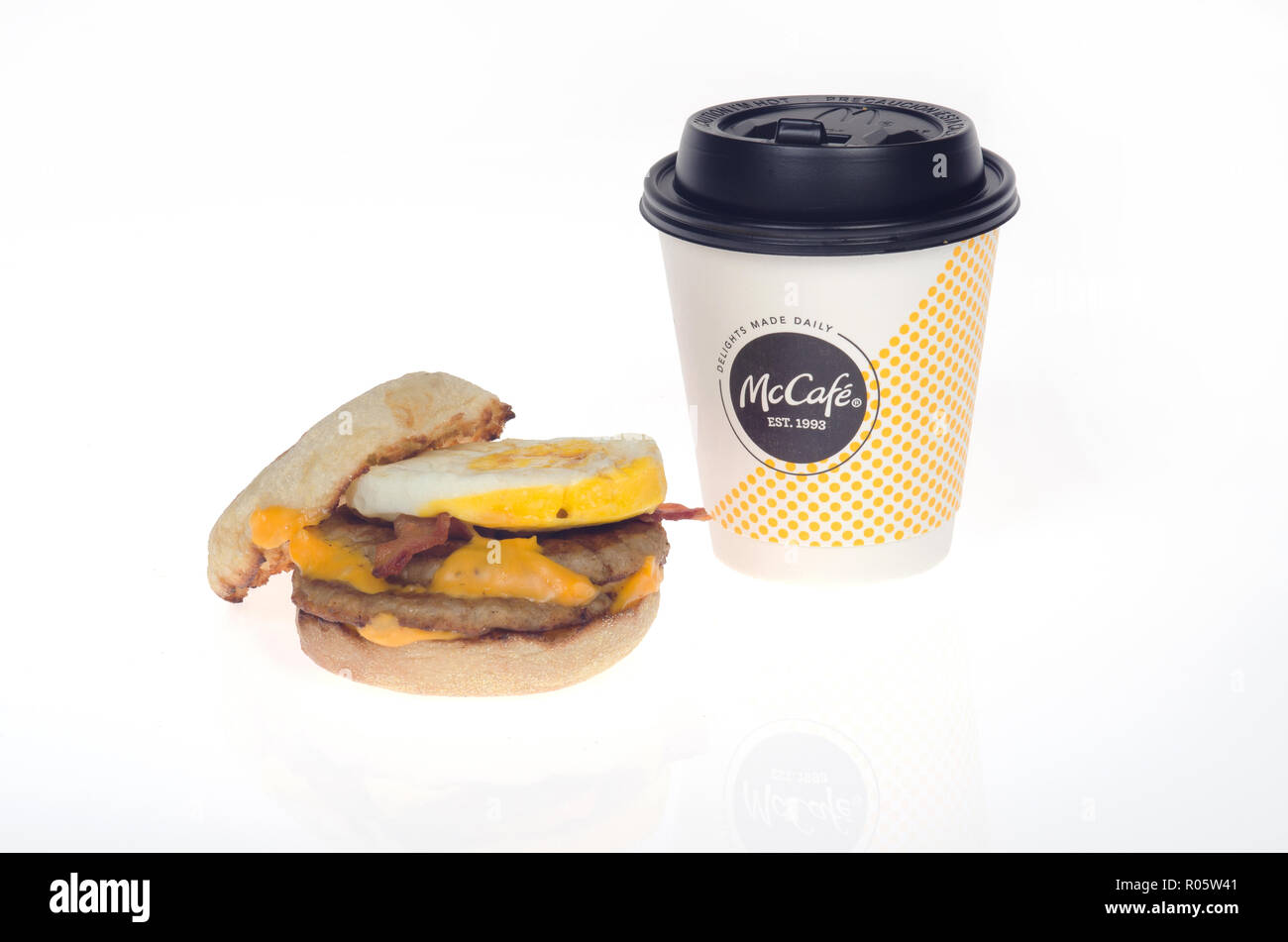 McDonalds nuevo Triple Stack Egg McMuffin sándwich w/ 2 salchichas empanadas, 2 tiras de tocino, 2 lonchas de queso americano en panecillo inglés y taza de café Foto de stock