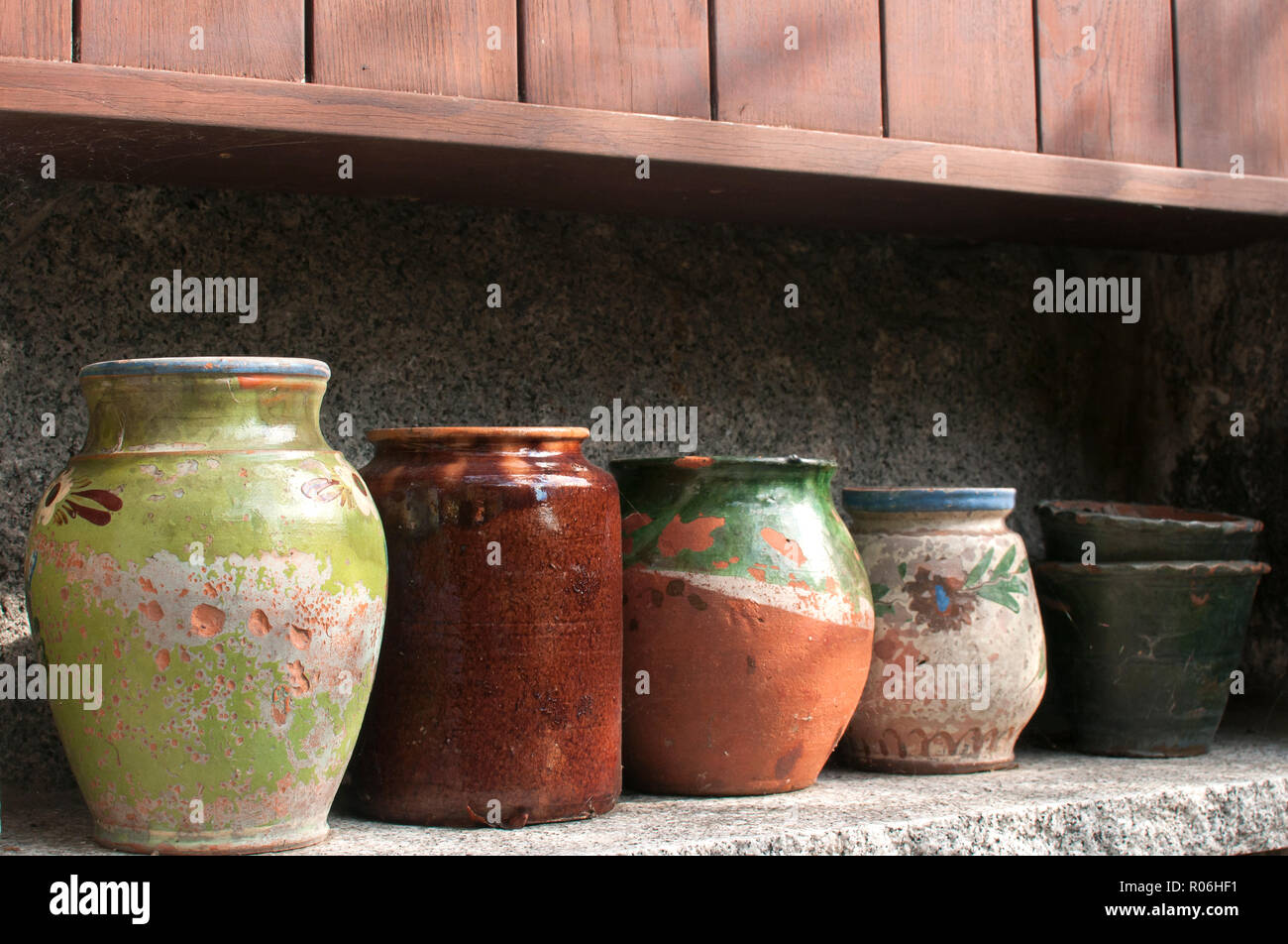 Varias vasijas de cerámica uno junto al otro en una fila en el nicho de  piedra en el jardín de la casa wall Fotografía de stock - Alamy