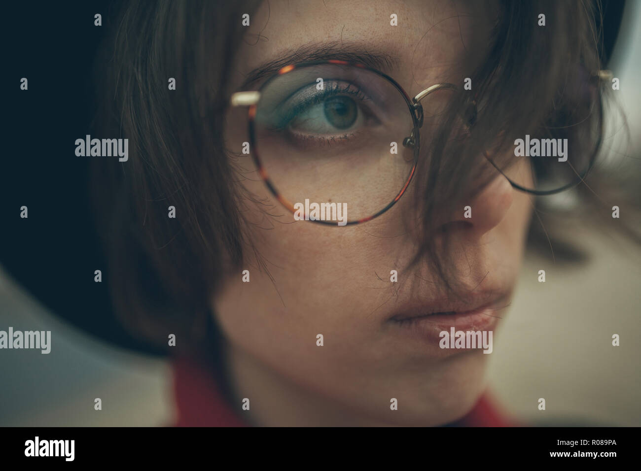 Retrato de joven mujer con gafas, pensativo en noche durante el crepúsculo. Foto de stock