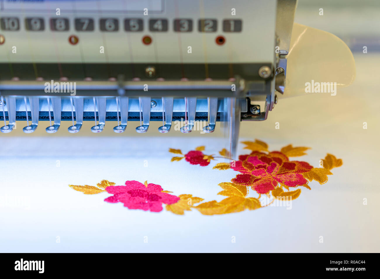 Máquinas de bordar computarizada. Máquina de coser sobre fondo borroso.  taller textil. closeup Fotografía de stock - Alamy