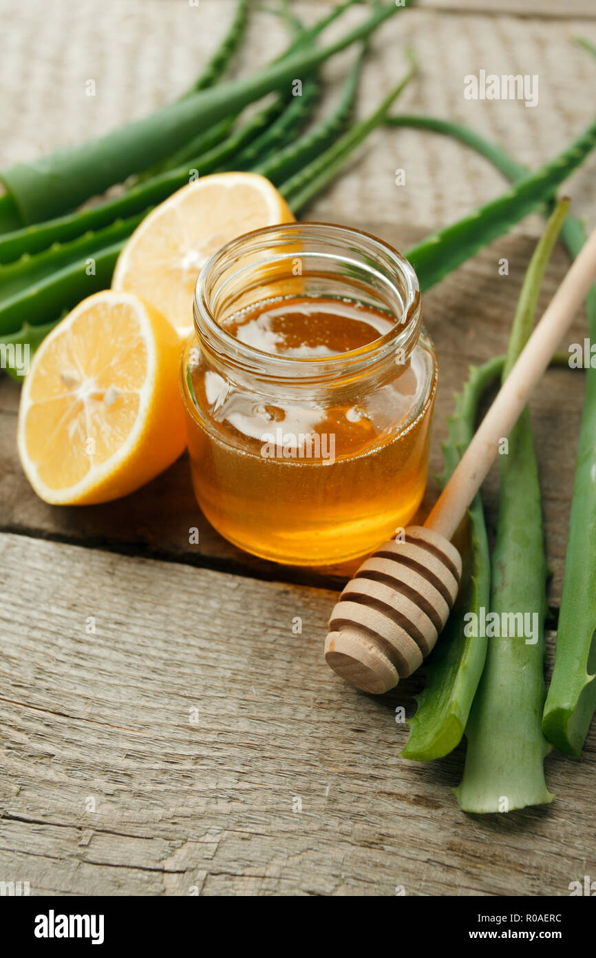 Inicio spa cremas ingredientes. En tarro de vidrio amarillo miel y limón, Aloe Vera, belleza natural producto closeup Foto de stock