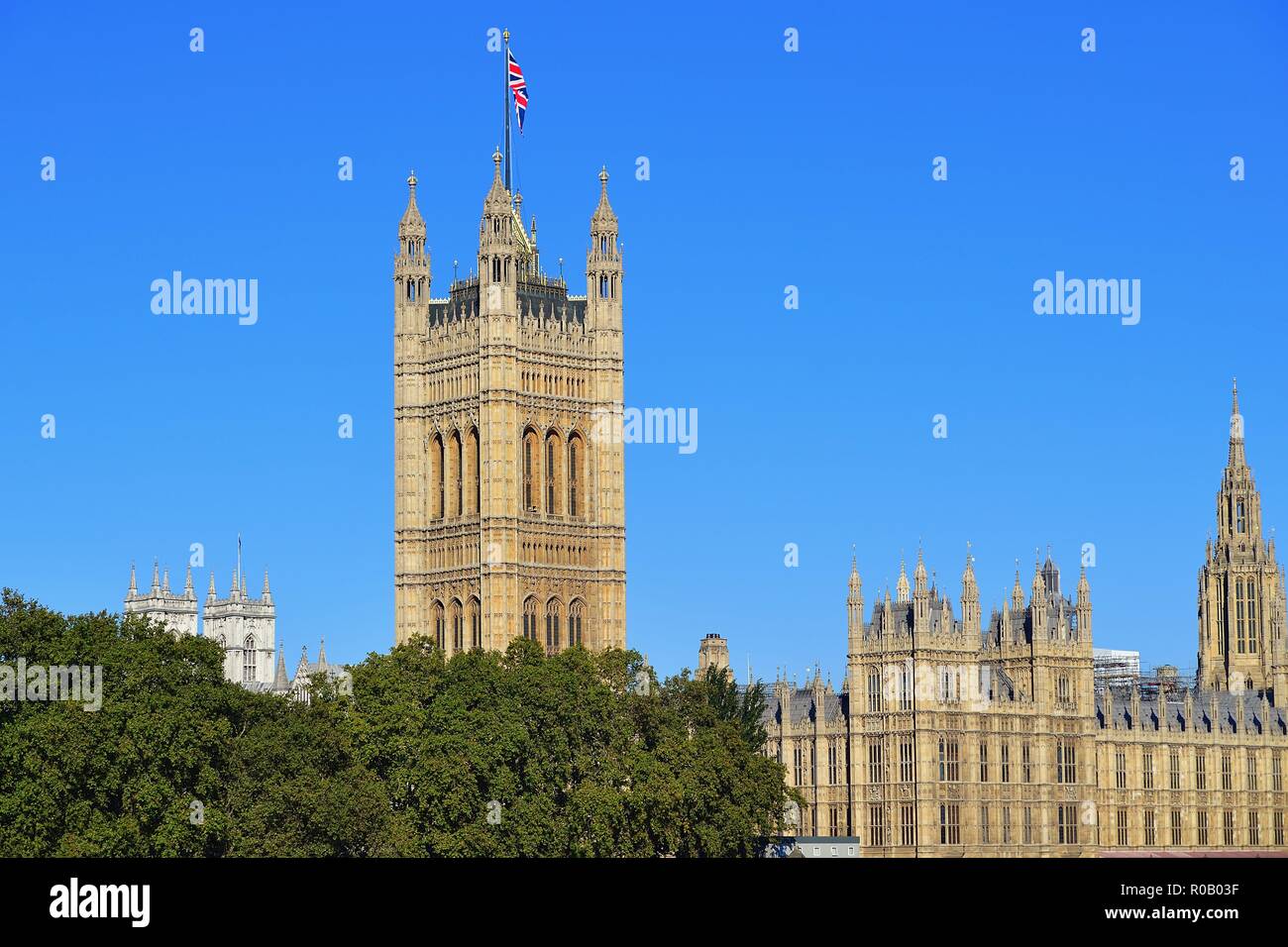 Londres, Inglaterra, Reino Unido. Victoria de la torre, con la Union Jack volaba desde su azotea, y las Casas del Parlamento más allá del río Támesis. Foto de stock