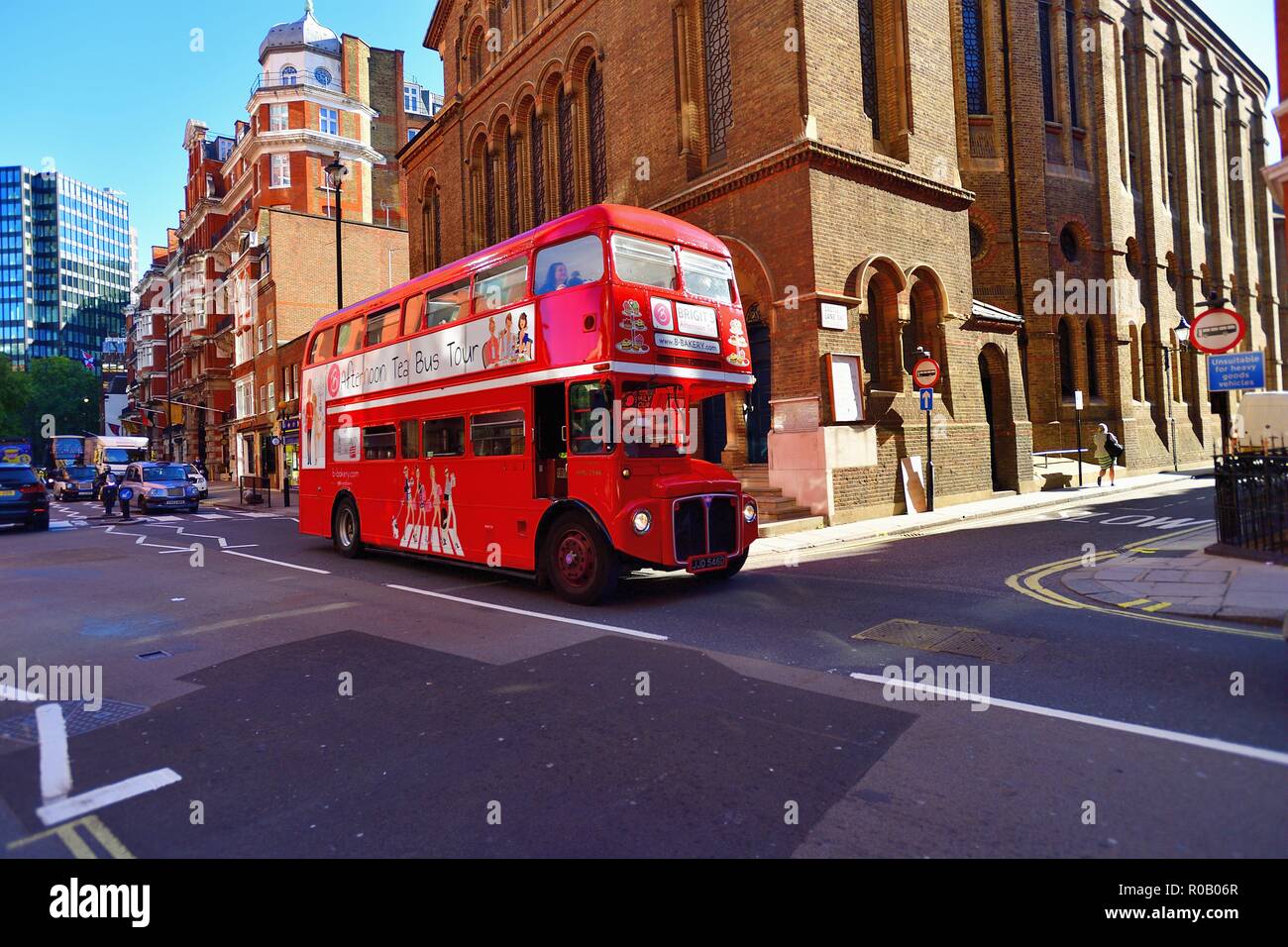 Londres, Inglaterra, Reino Unido. Tráfico, incluyendo una viejísima Routemaster double-Decker Bus Tour convierten al servicio de autobuses. Foto de stock