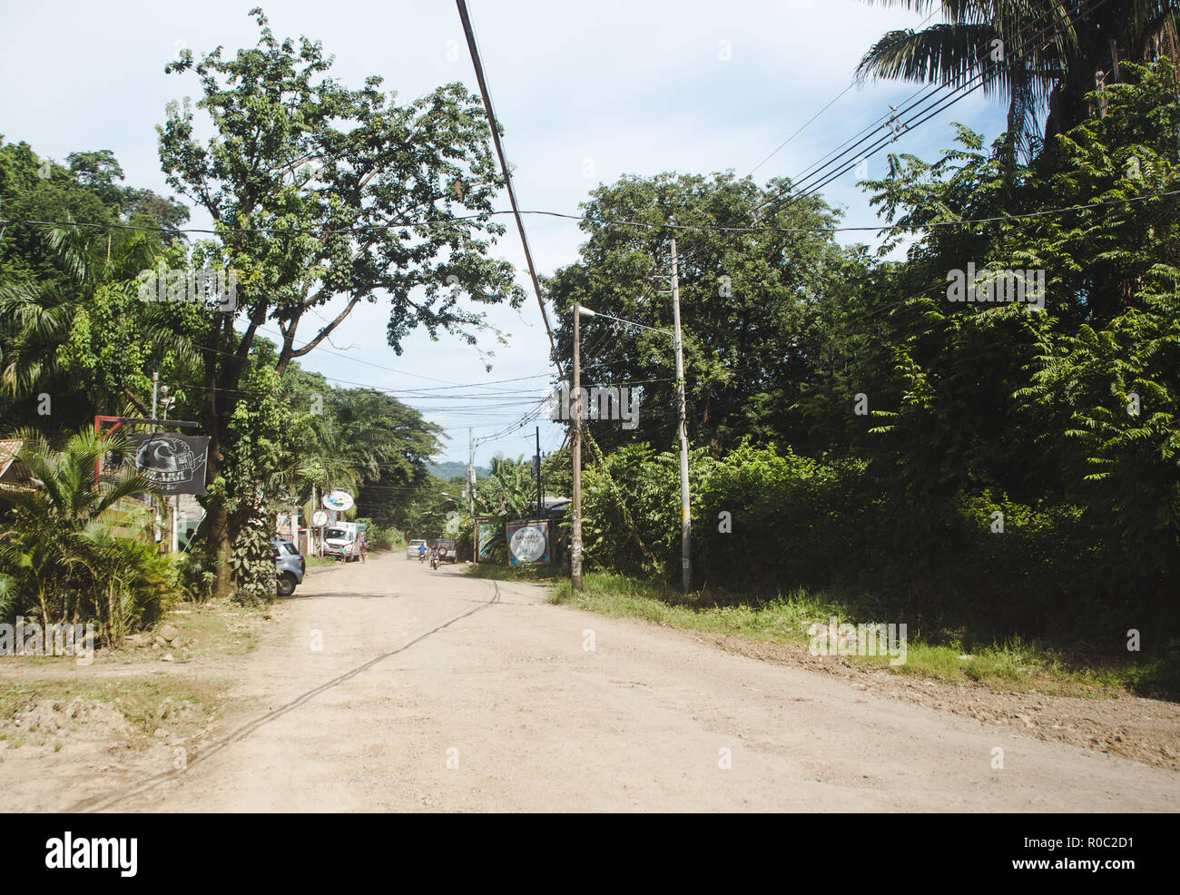 Polvorienta carretera principal a través de la pequeña ciudad de Santa Teresa, en la costa del pacífico de la península de Nicoya, Costa Rica Foto de stock