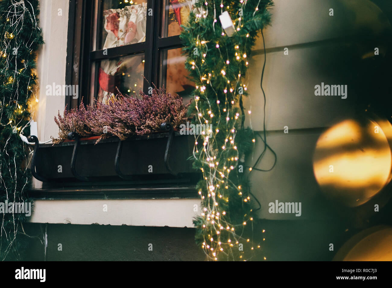 Elegante decoración de navidad, guirnaldas y luces de ramas de abeto con  adornos de cristal en unión de las calles de la ciudad. Calle festiva  decoración e iluminación Fotografía de stock -