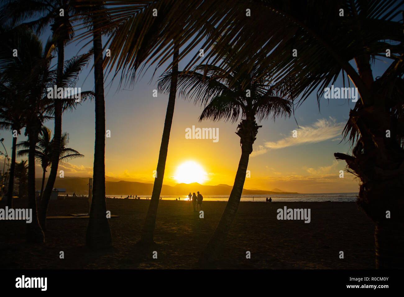 Silueta de la gente en la playa, en la hermosa puesta de sol Foto de stock