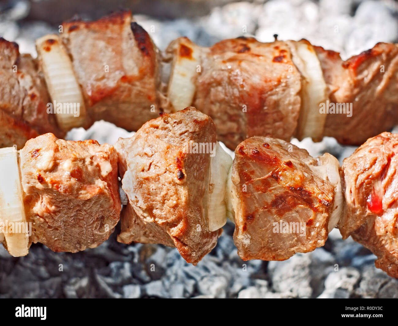 Una mini barbacoa de cerdo fresco en los palos de madera se cocina