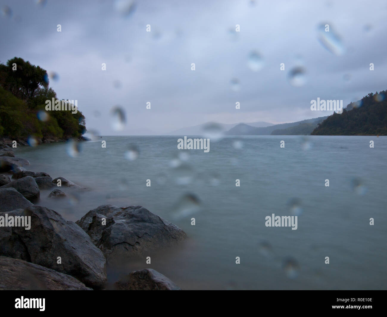 El tiempo lluvioso en un lago de las montañas rocosas Foto de stock