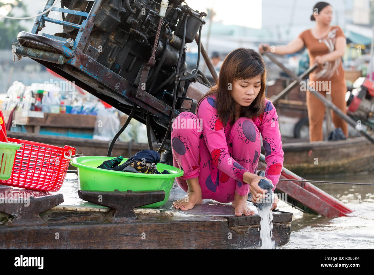 CAN THO, Vietnam, 12 de diciembre de 2014:Una mujer está lavando la ropa a bordo de un barco comercial en El Cai Rang mercado flotante sobre el río Mekong i Foto de stock