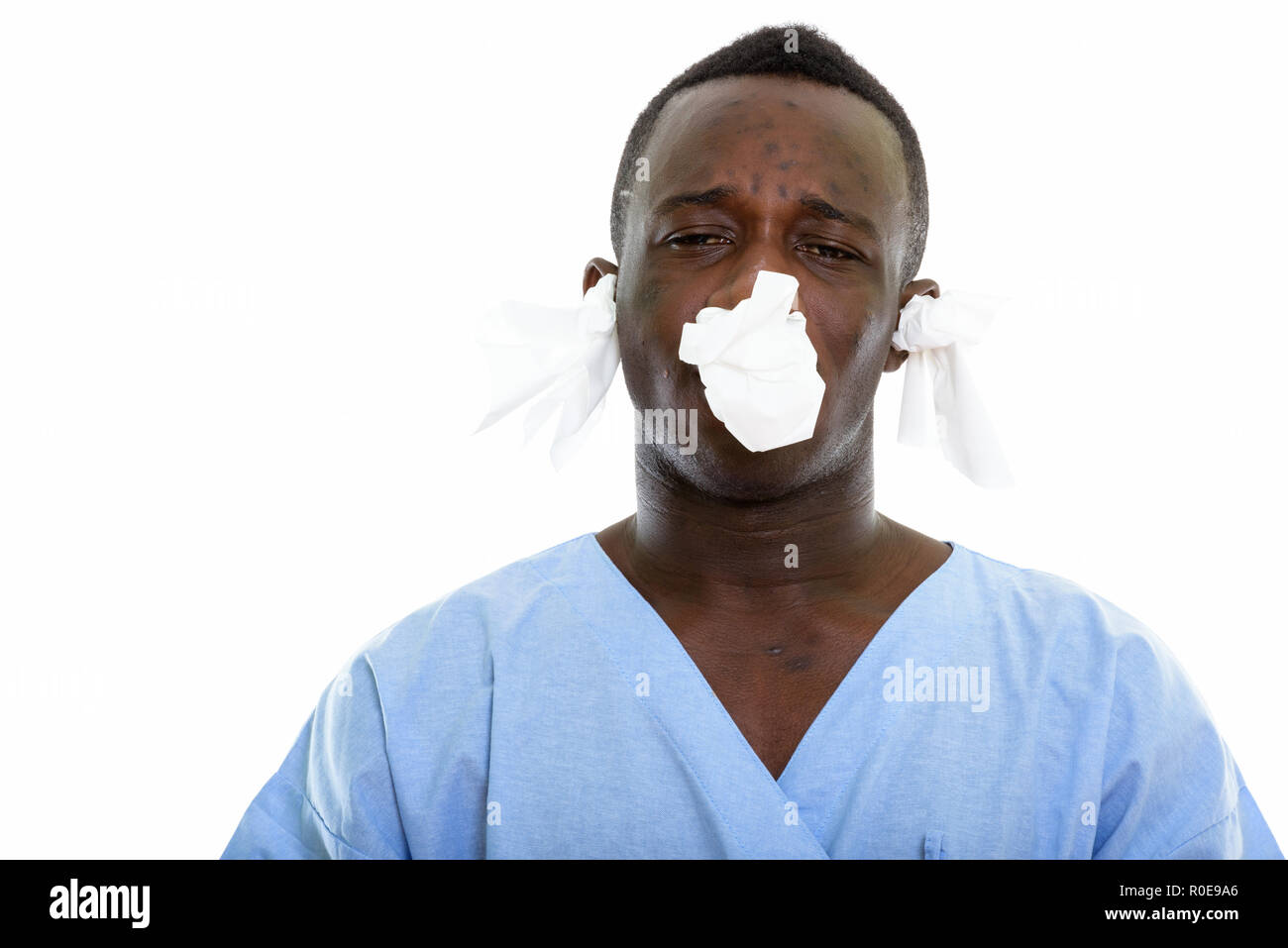 Foto de estudio de joven hombre negro africano en busca del paciente enfermo con Foto de stock