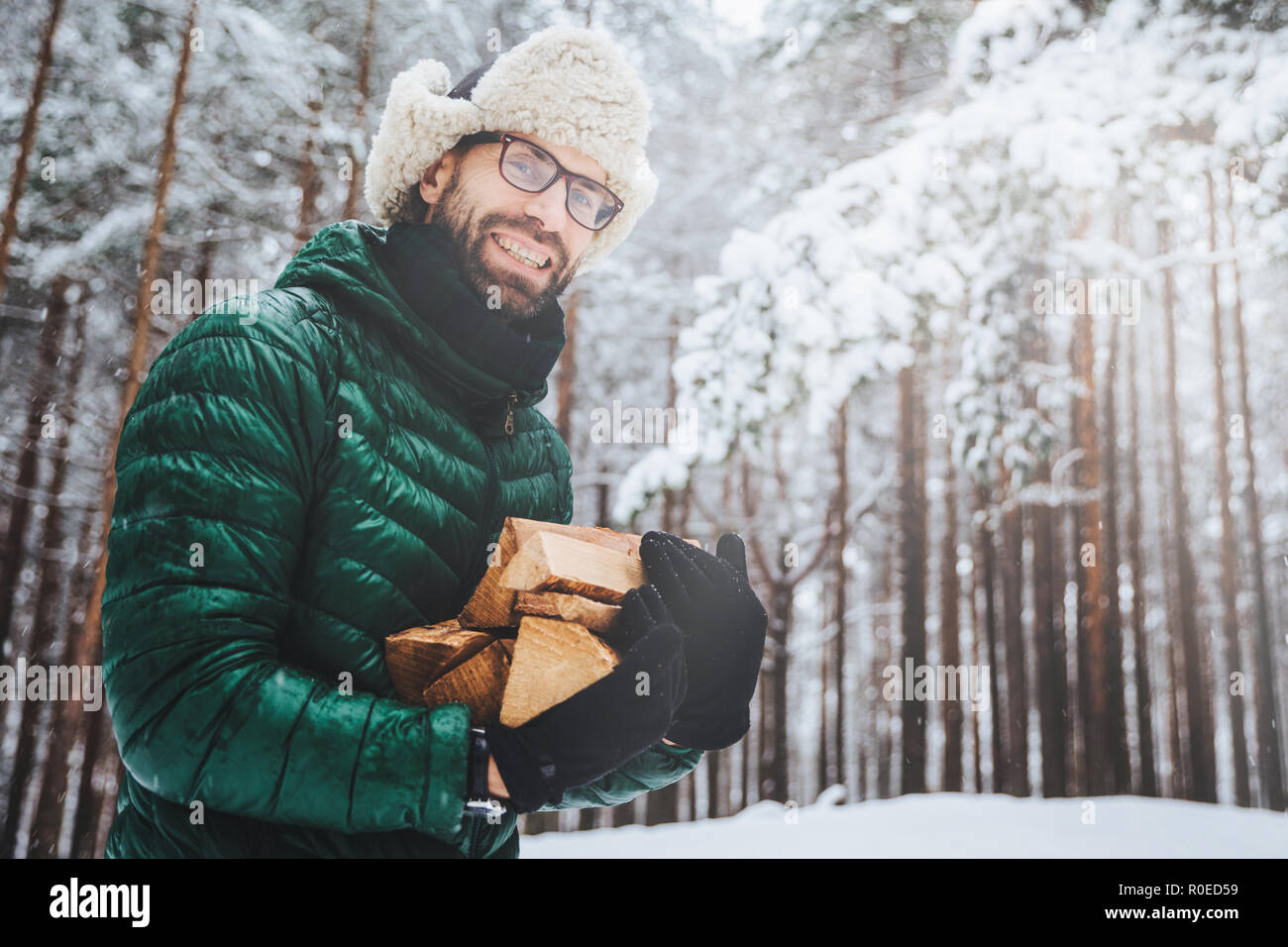 Hombre barbudo feliz con gafas de sol en un clima soleado y nevado concepto  de pasar tiempo activo caminando después de una ventisca de nieve el tipo  sonriendo y usando una chaqueta de invierno