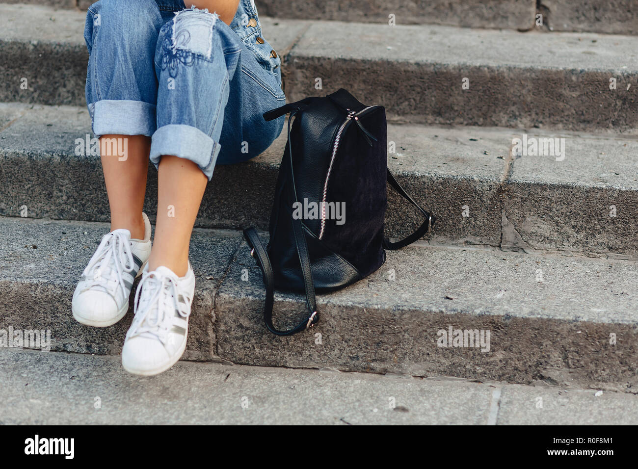 Piernas y bolsa closup joven chica bonita con maletín sentado en las  escaleras Fotografía de stock - Alamy
